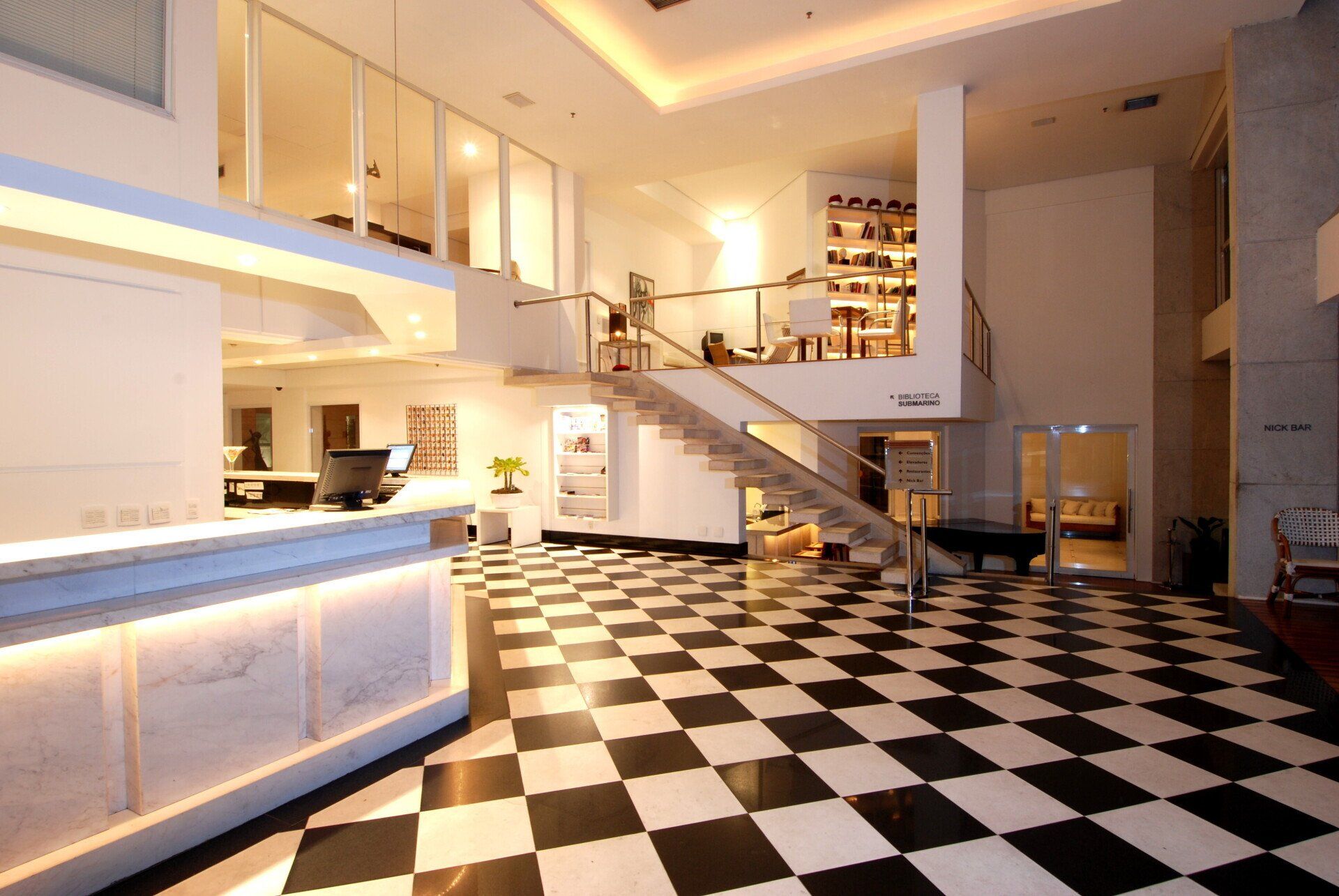 Um lobby de hotel com piso xadrez e escadas