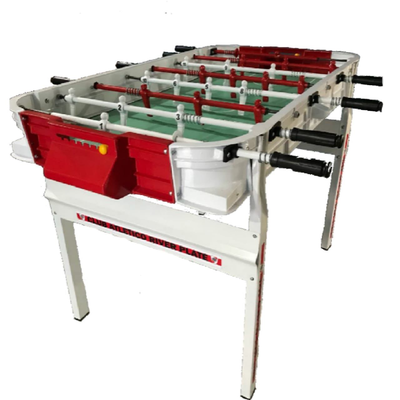 Una mesa de futbolín blanca y roja con una superficie de juego verde sobre un fondo blanco liso.