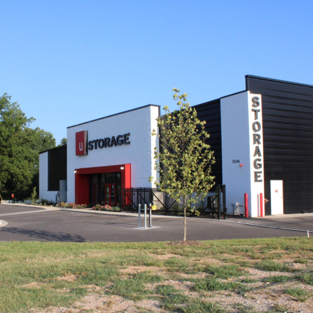 Modern self-storage facility with red entrance accents and large “STORAGE” signage under a blue sky