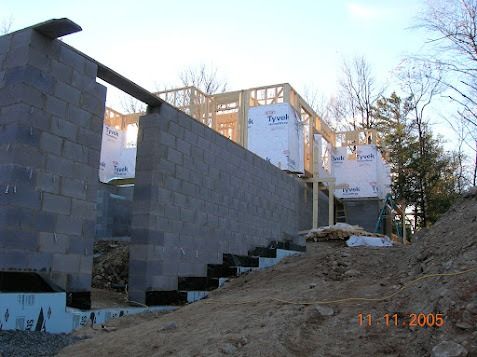 Partially built concrete block wall with stairs, on a construction site in winter