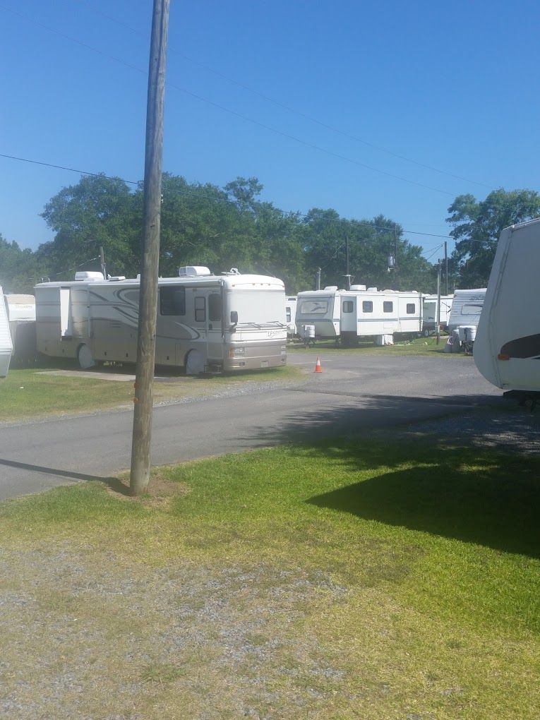 A white RV is parked in a parking lot