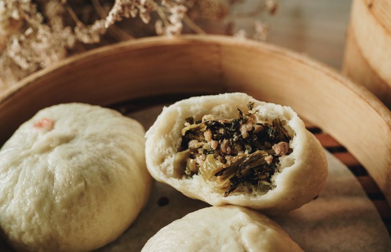 A close up of a bamboo steamer filled with dumplings.