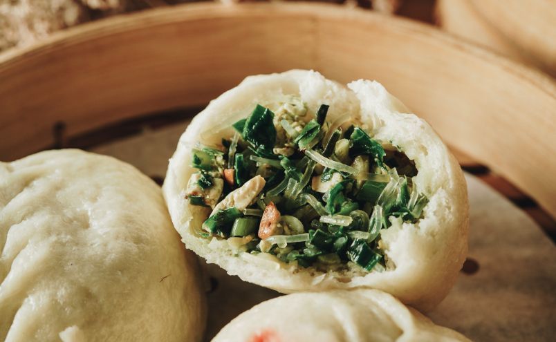 A close up of a bamboo steamer filled with dumplings.