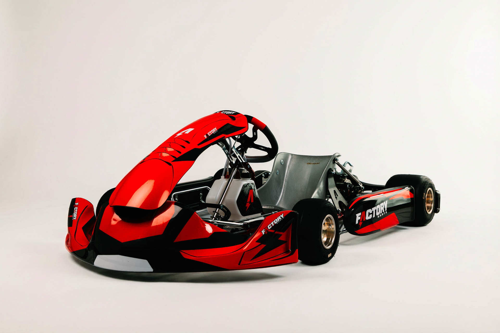 Red and black race car on a white background, shown in side view with exposed cockpit and rear wing