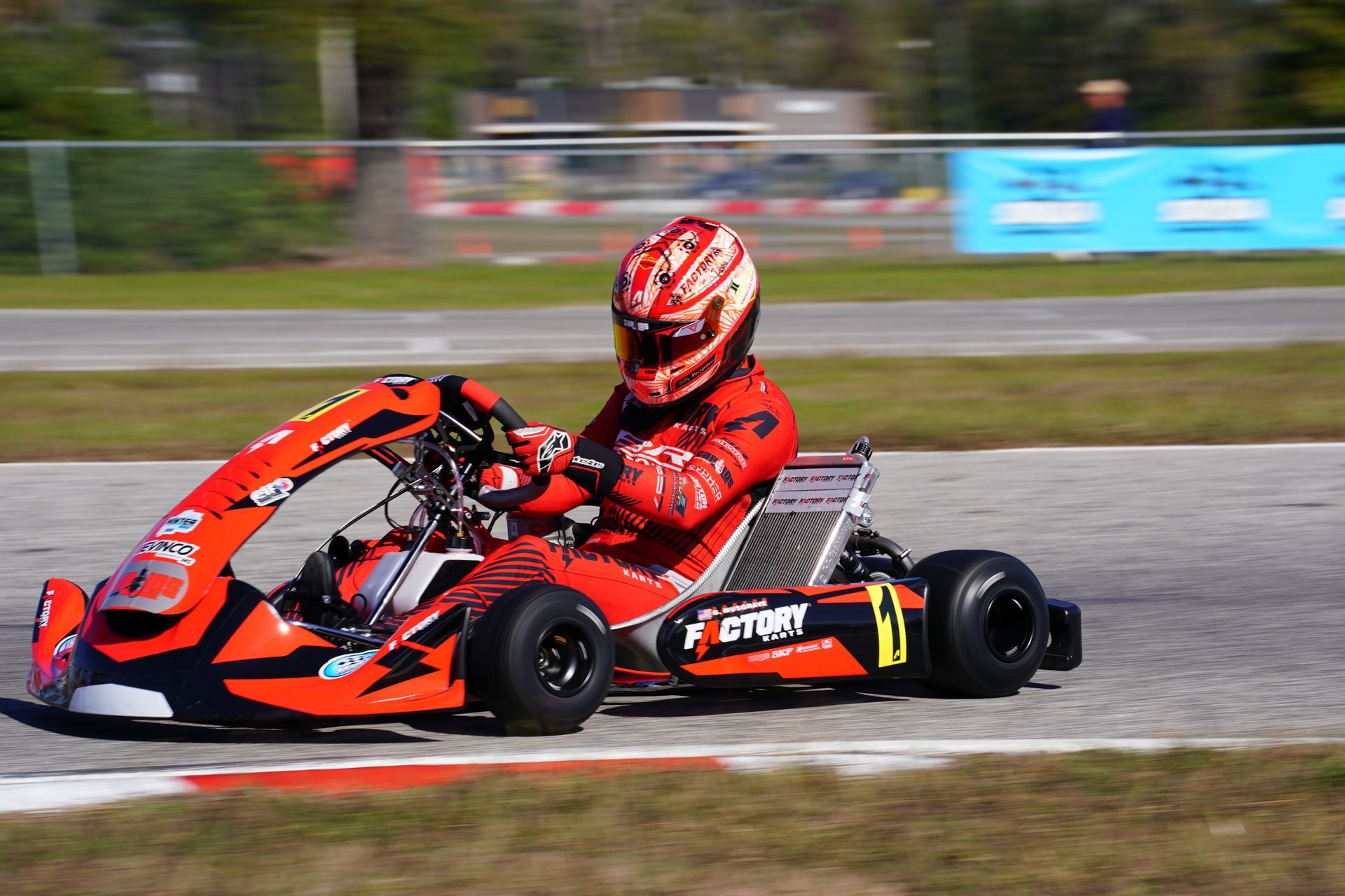 Red go-kart racer leaning into a turn on an outdoor track
