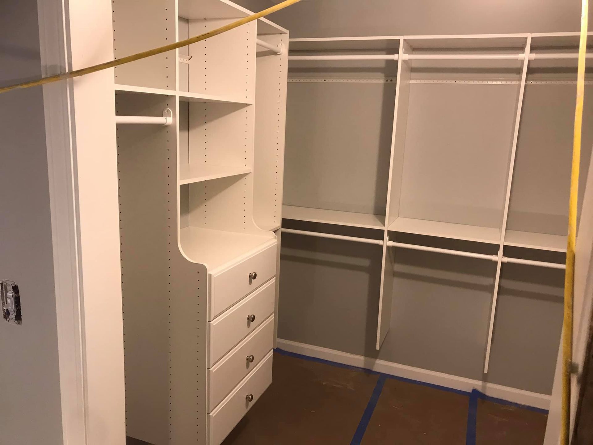 A walk in closet with a measuring tape hanging from the ceiling.