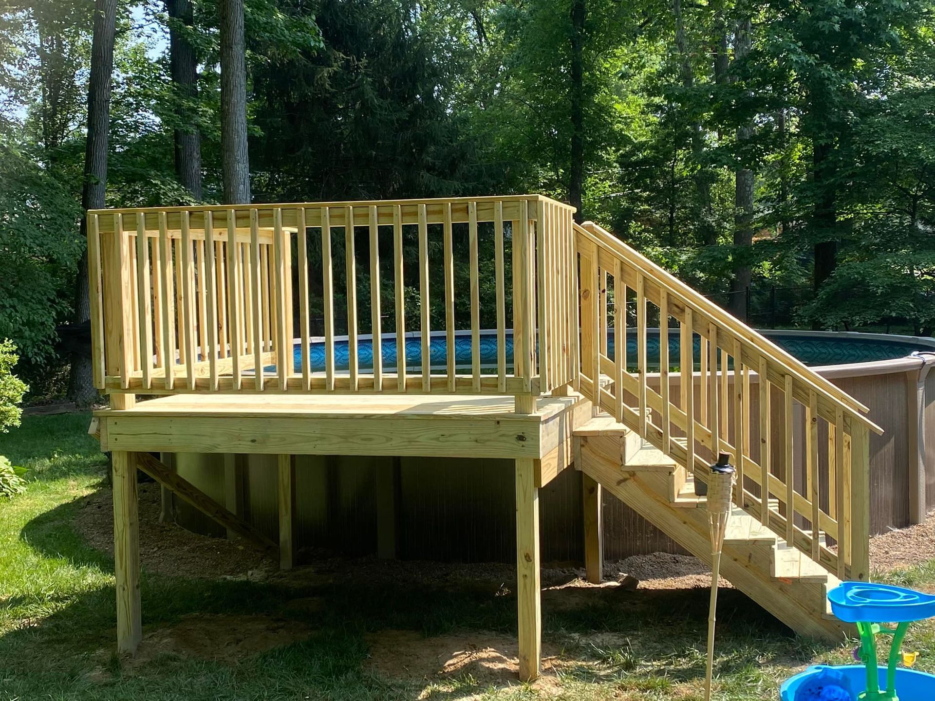 A wooden deck with stairs leading up to a pool