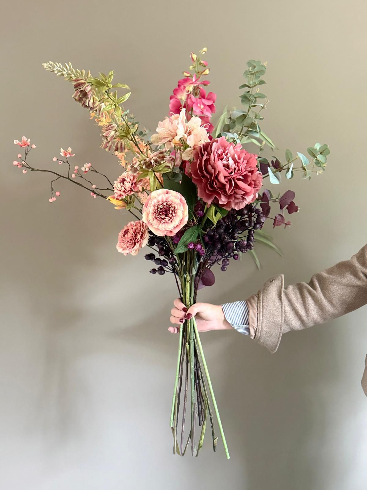 Boeket zijden bloemen in roze en pastelkleuren in een groenblauwe vaas, samengesteld door Marlou en Bloemen.