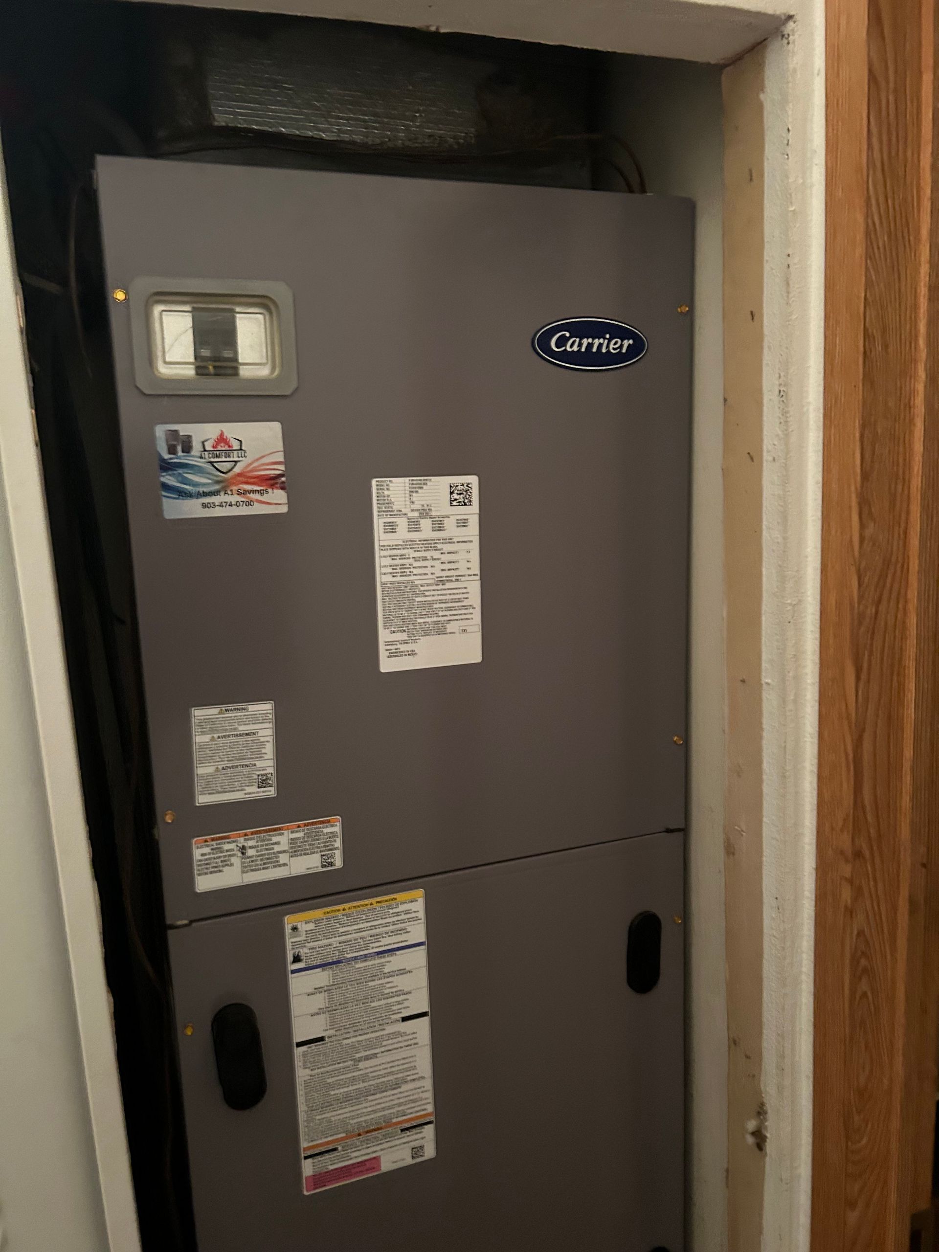 Gray Carrier HVAC unit in a closet.