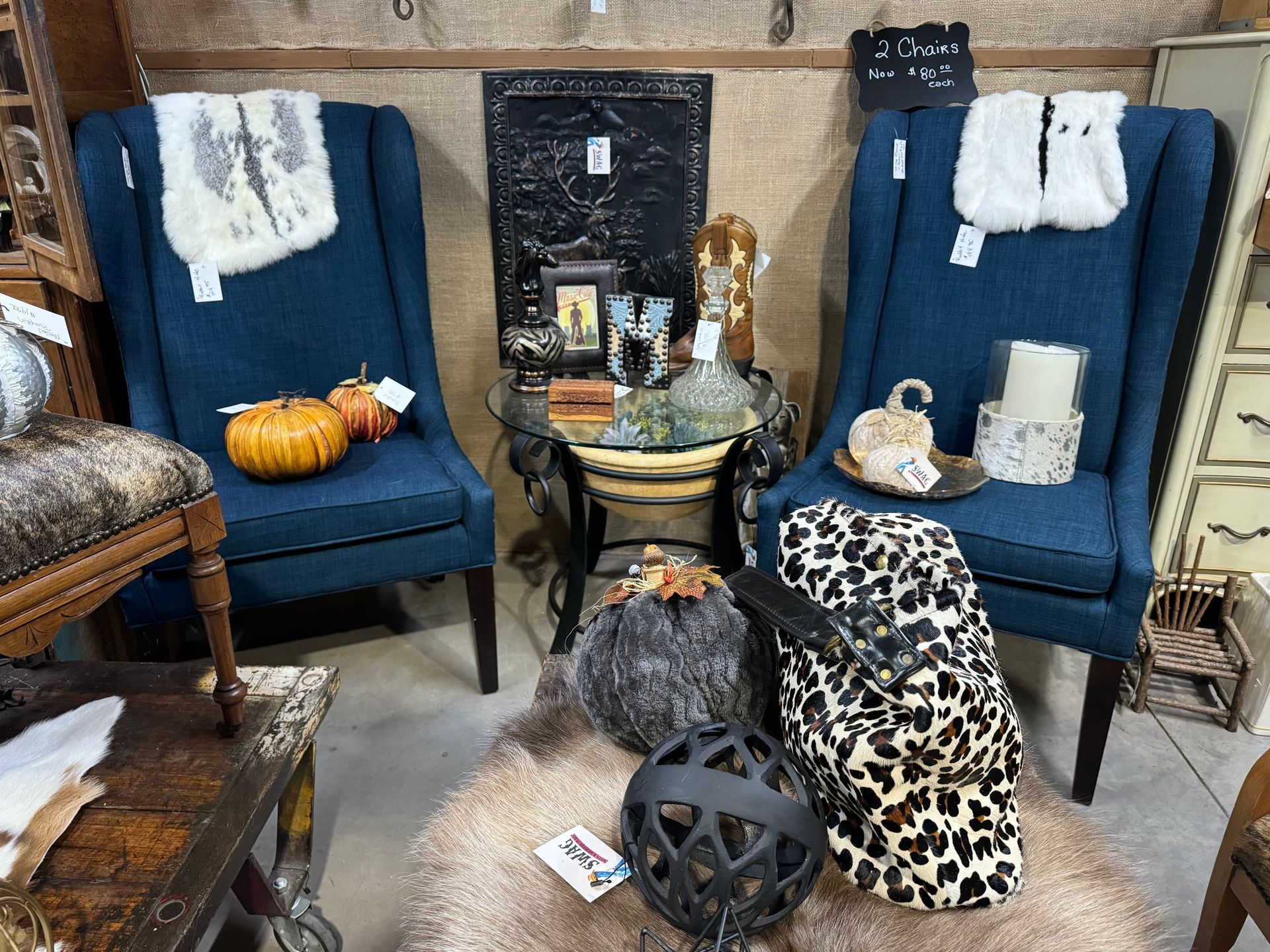 Two blue armchairs in a room with a small round table between them, decorated for fall.