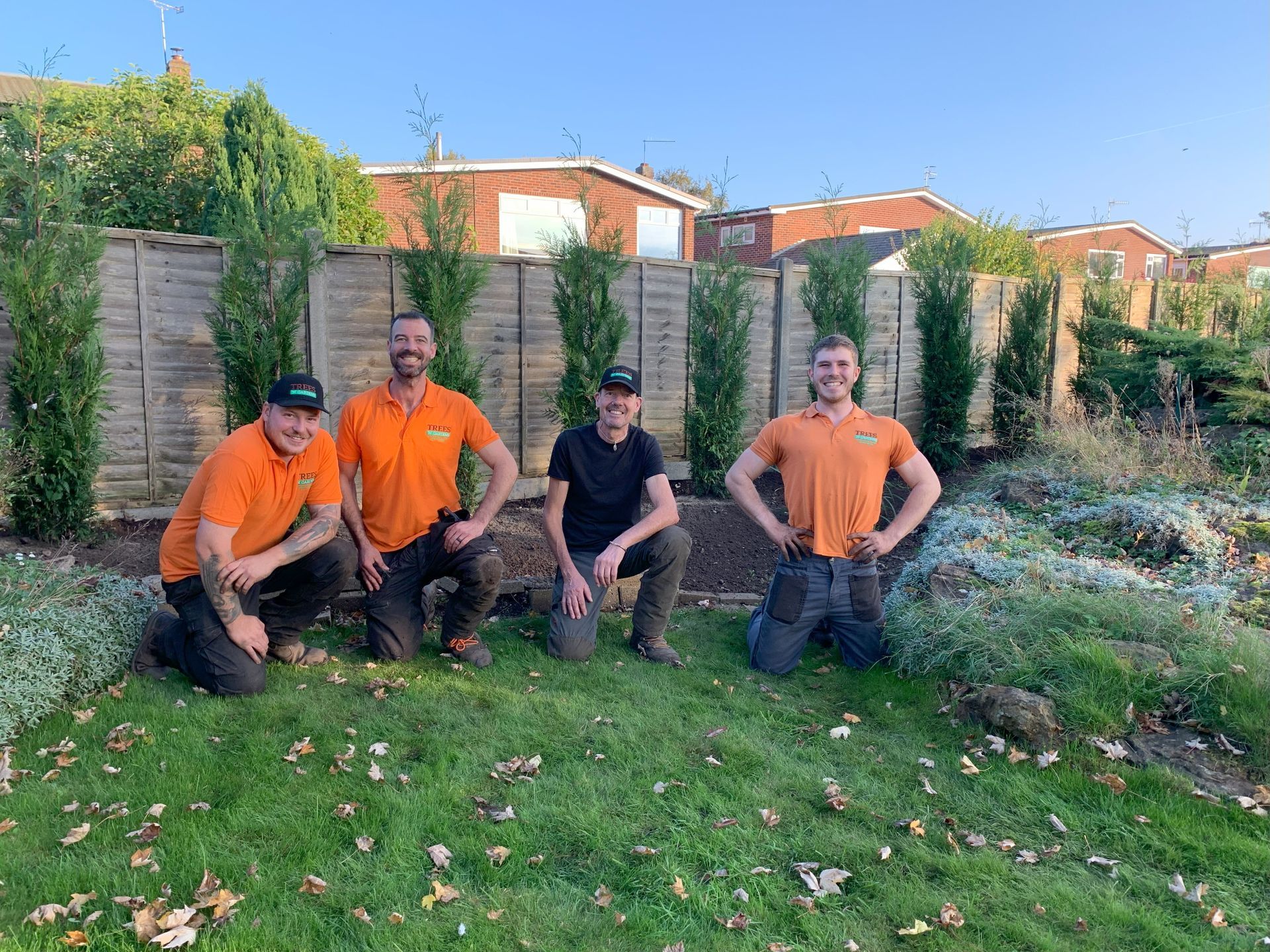 A group of men are posing for a picture in a garden.