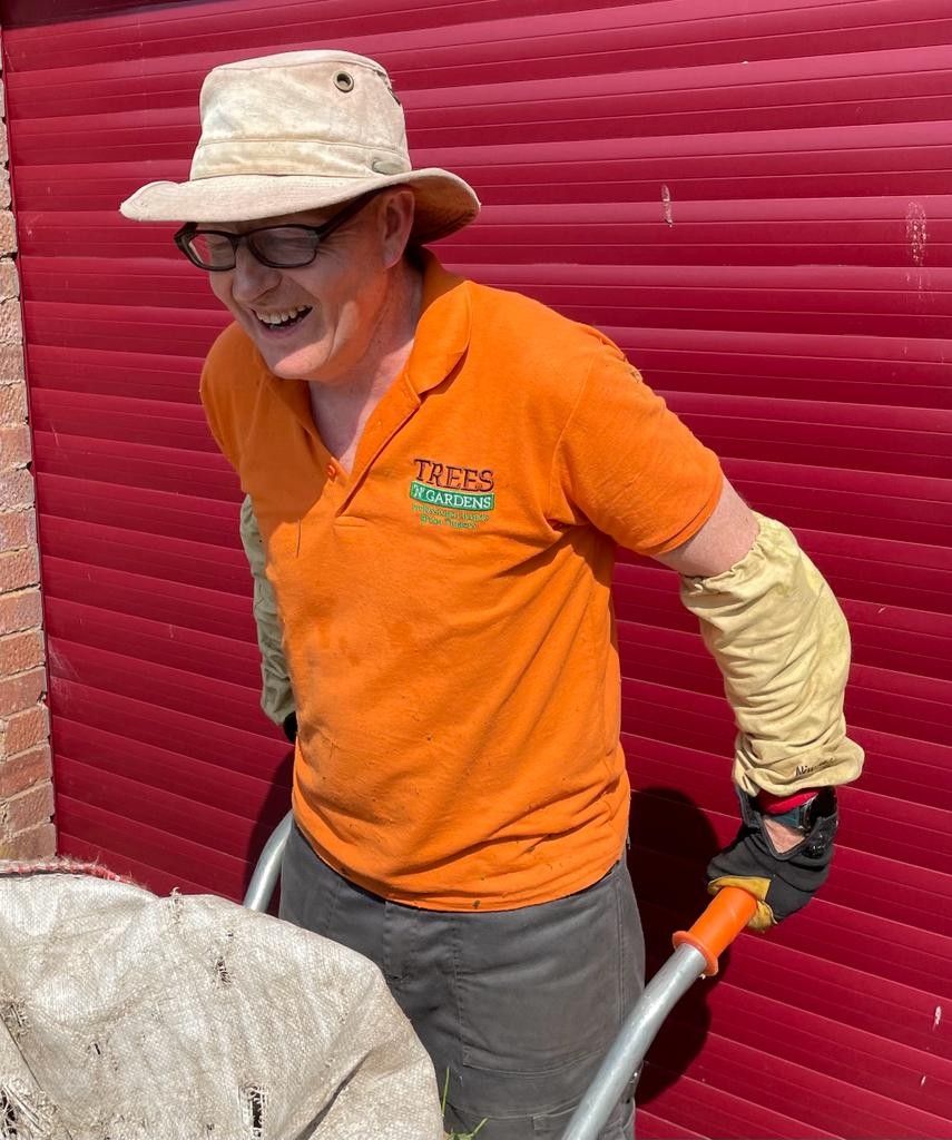 A man wearing an orange shirt with the word trees on it