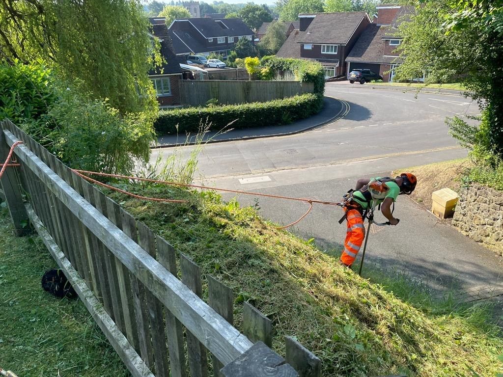 A man is cutting a fence with a rope.