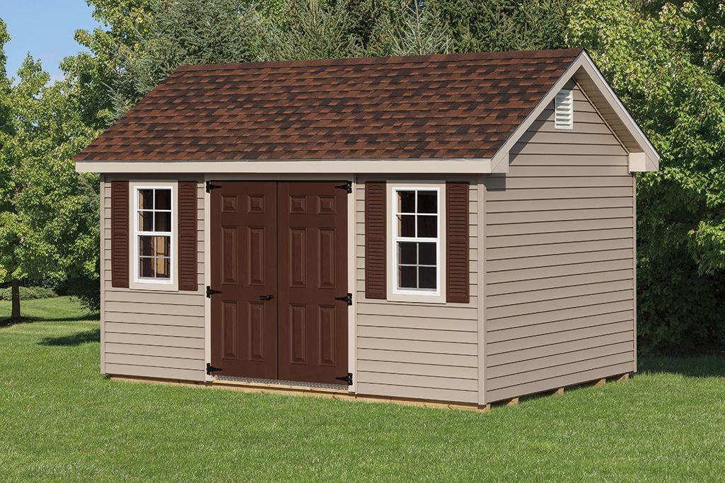 Classic Garden Cottage with tan vinyl siding, brown double doors, 2 white windows with brown shutters, roof overhangs on all sides, and a brown asphalt roof.