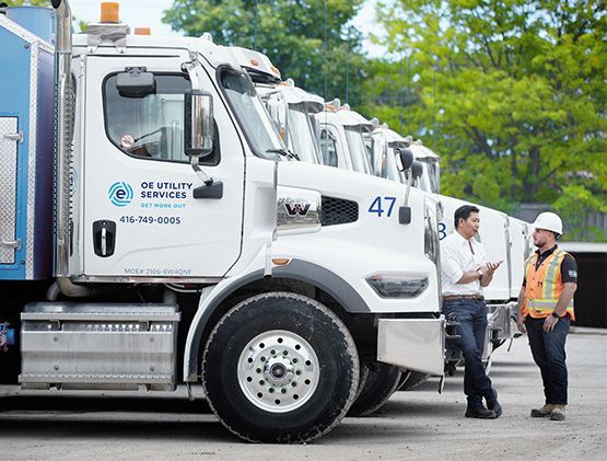 Line of hydrovac truck with two employees outside