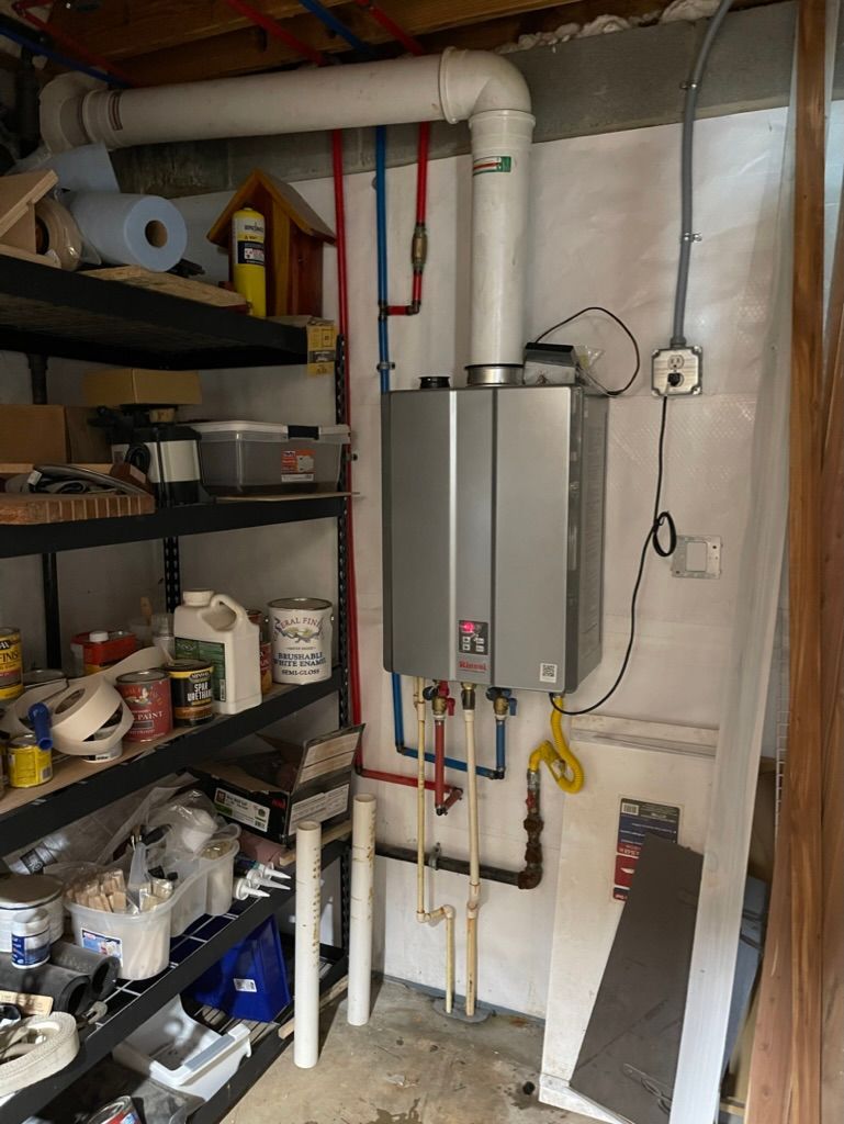 Utility room with water heater, pipes, shelving, and stored supplies