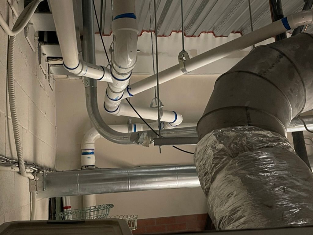 Exposed ceiling pipes and ducts in a utility or maintenance space