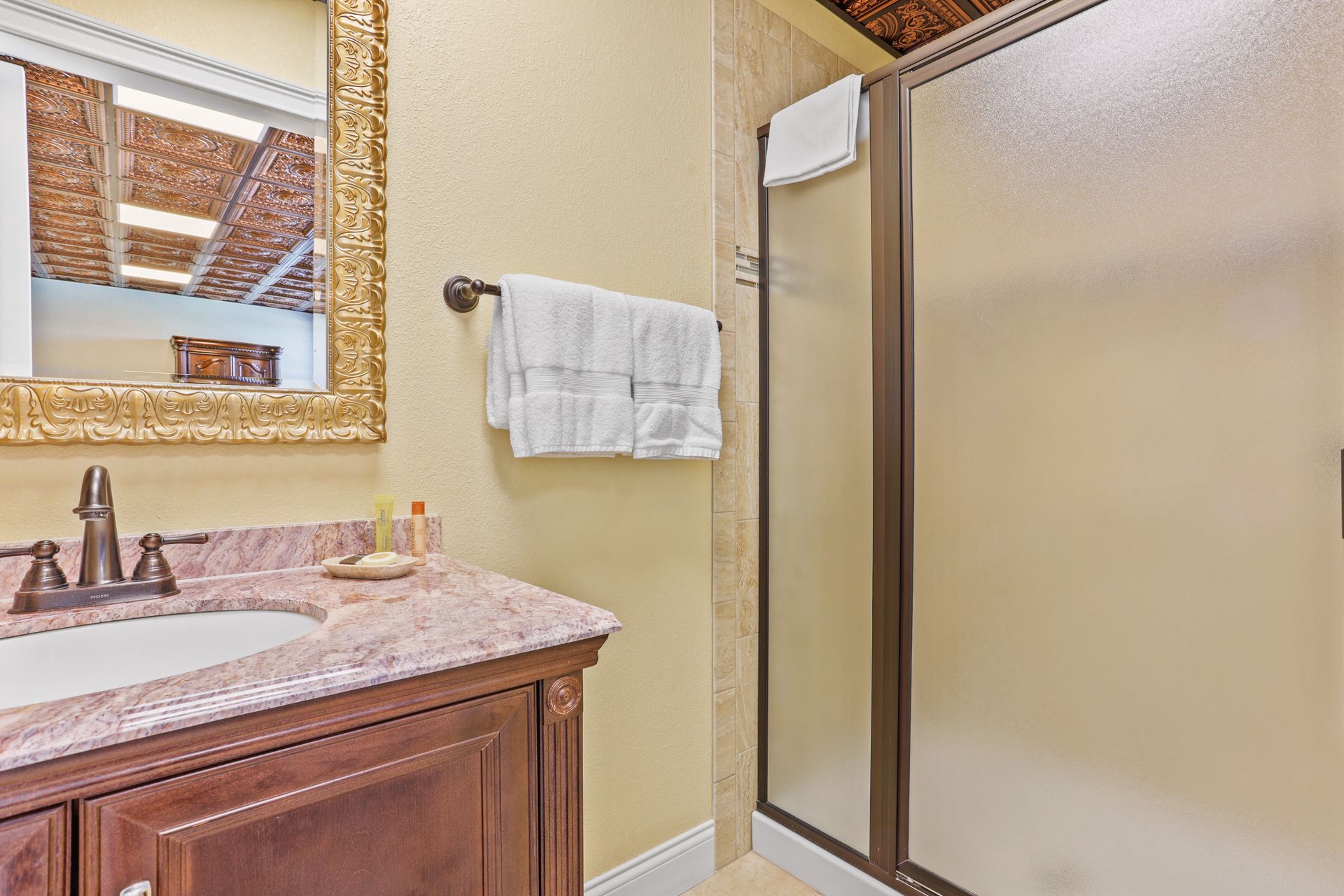 A bathroom with a sink , mirror , and walk in shower.