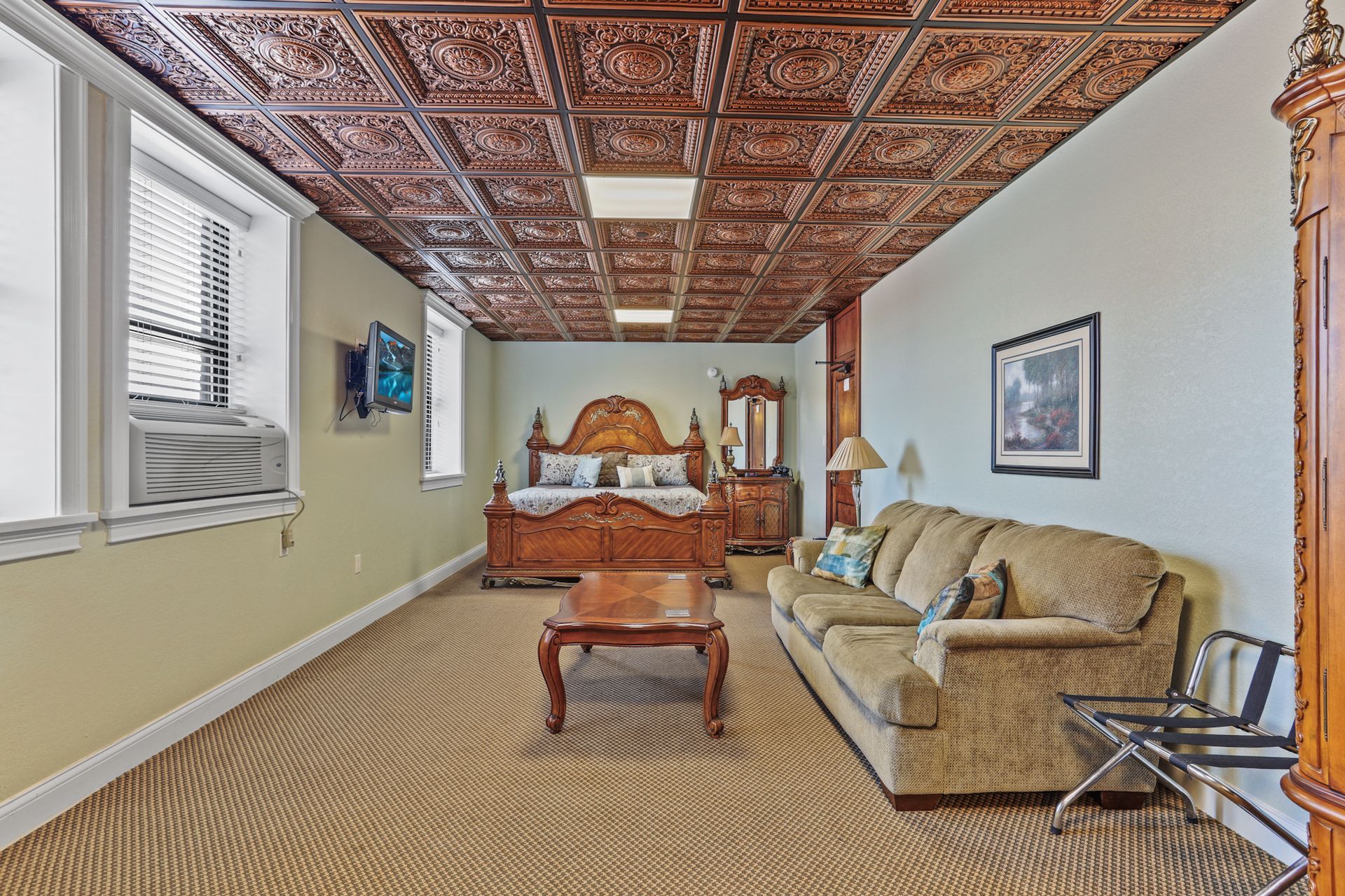 A living room with a couch , bed , coffee table and clock.