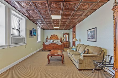 A living room with a couch , bed , coffee table and clock.