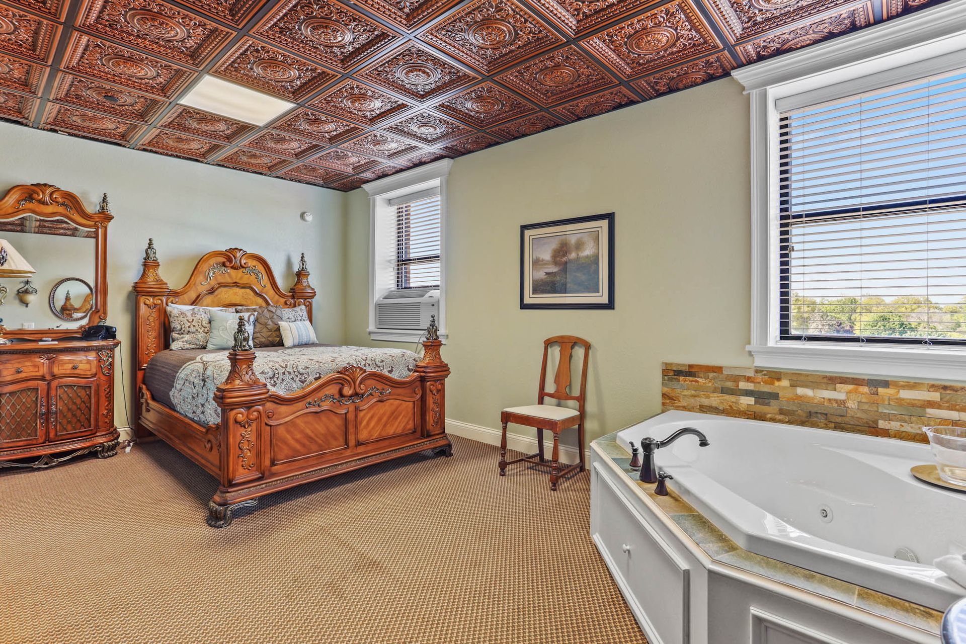 A bedroom with a king size bed and a jacuzzi tub.