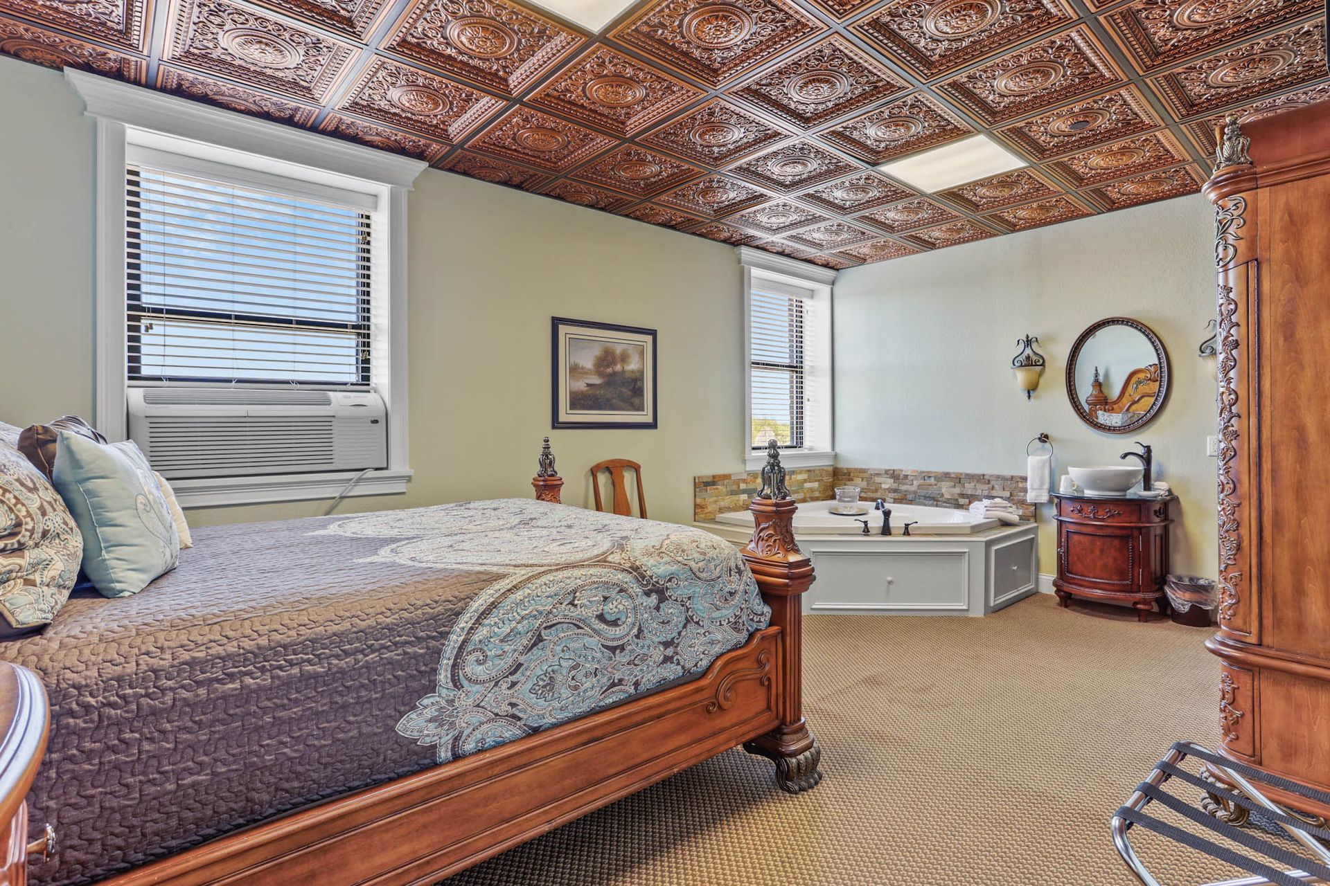 There is a large bed in the middle of the room with a copper ceiling.