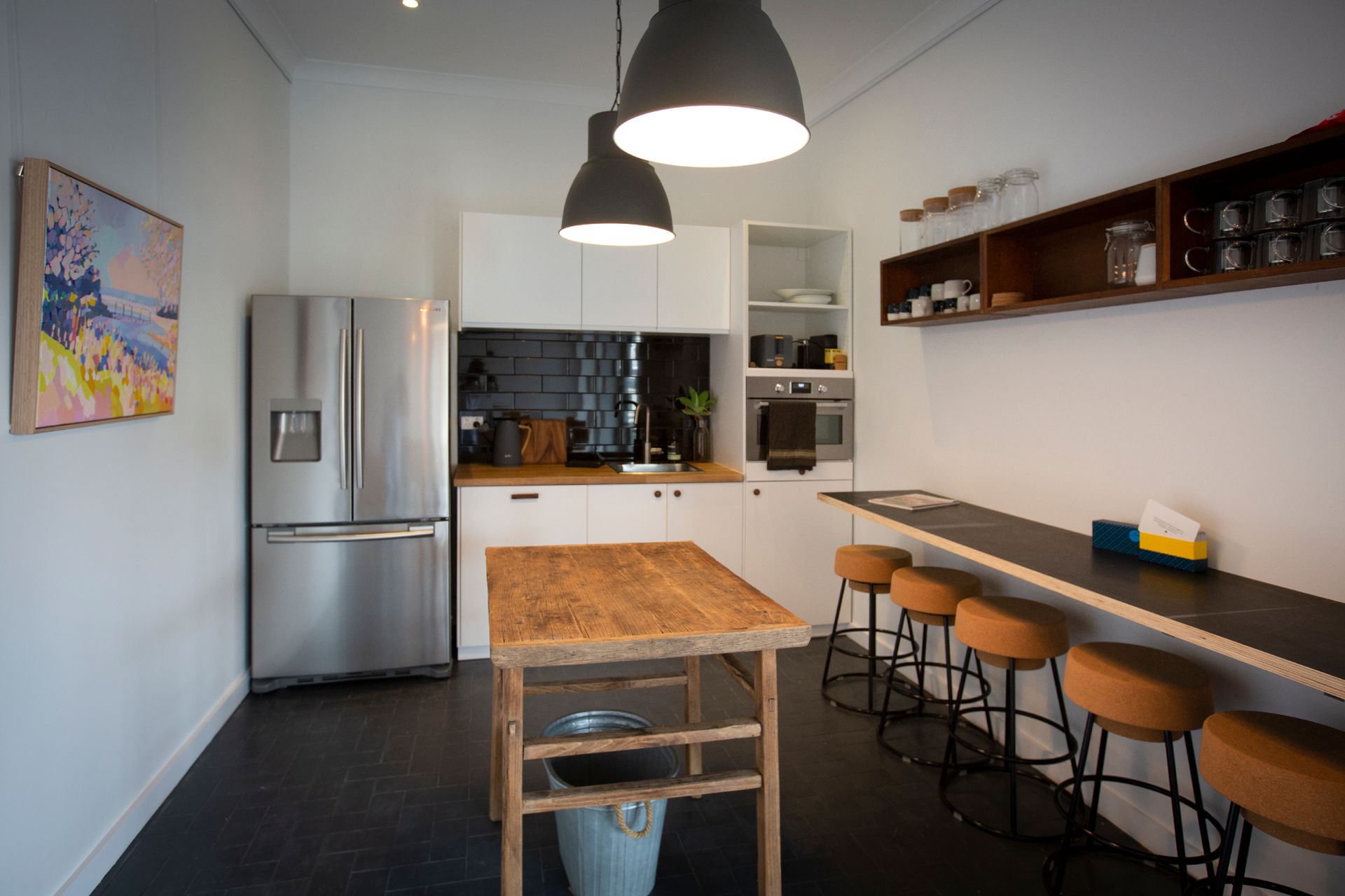 A kitchen with a wooden table and two black downlights — DG Electrical & Fire In Kiama, NSW