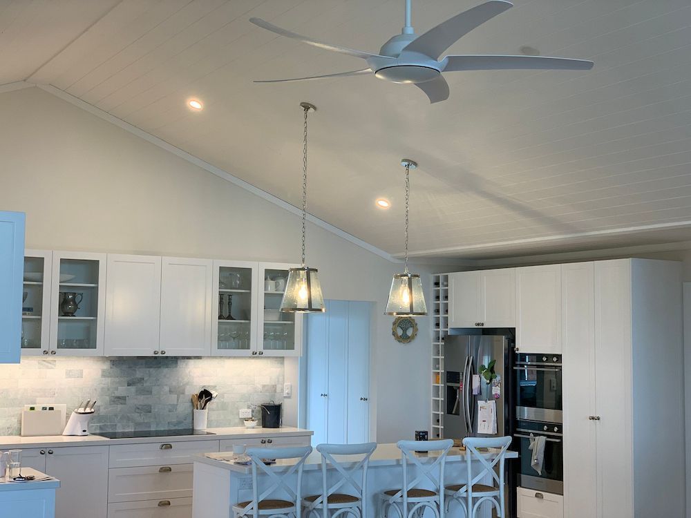 A Kitchen In A New Home With Hardwood Floors — DG Electrical & Fire In Gerringong, NSW