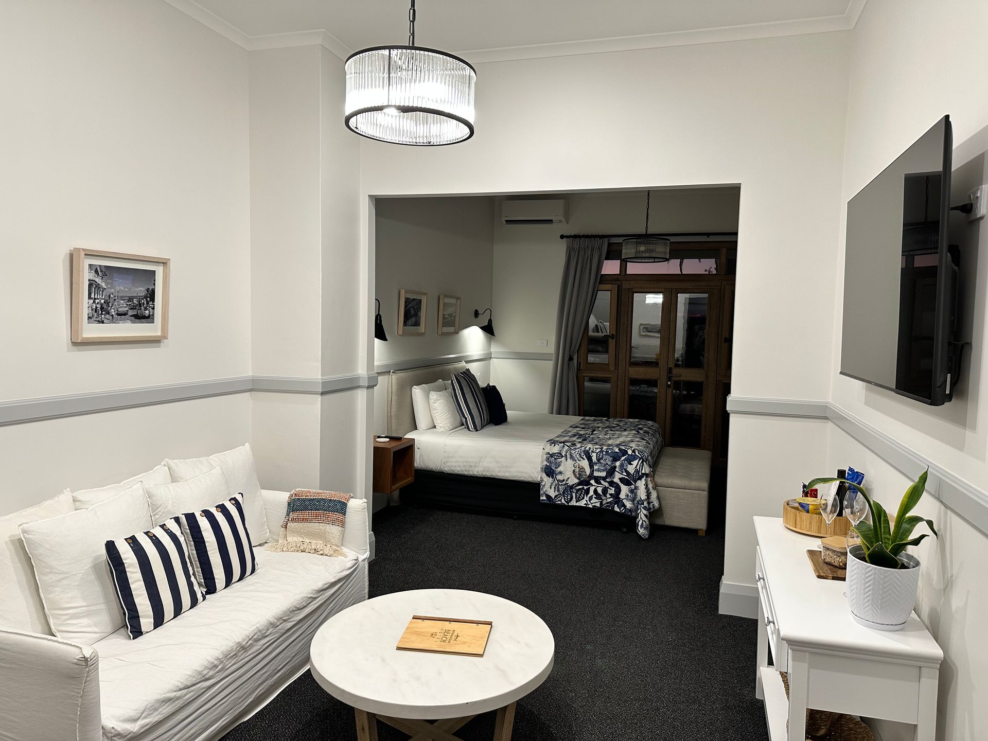 Living Room With White Sofa, Round Coffee Table, and a Doorway Into the Bedroom — DG Electrical & Fire In Kiama, NSW