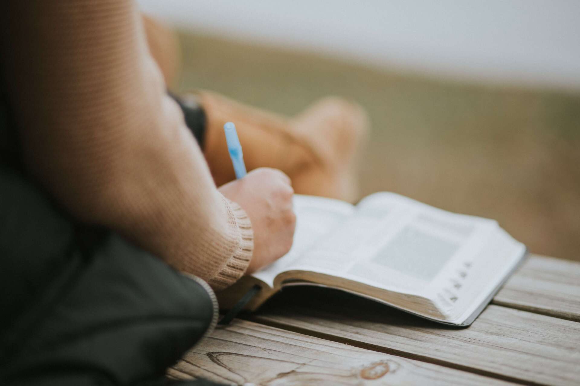 Person Writing a Eulogy in a Notebook