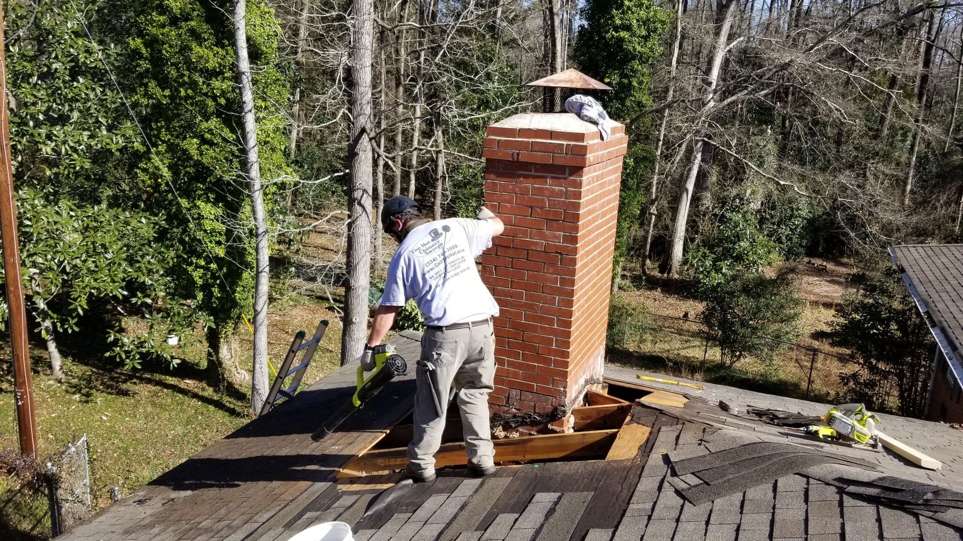 A man is working on a chimney on top of a roof.