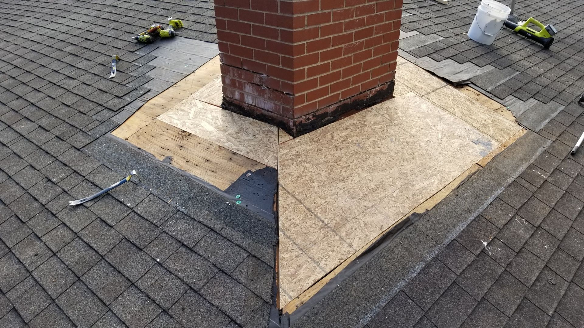 A brick chimney is sitting on top of a brick roof.
