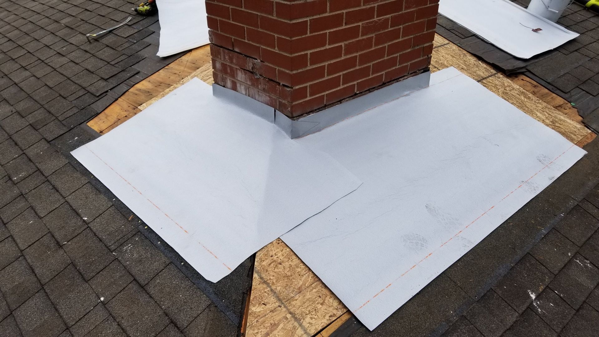 A brick chimney is being repaired on a brick roof