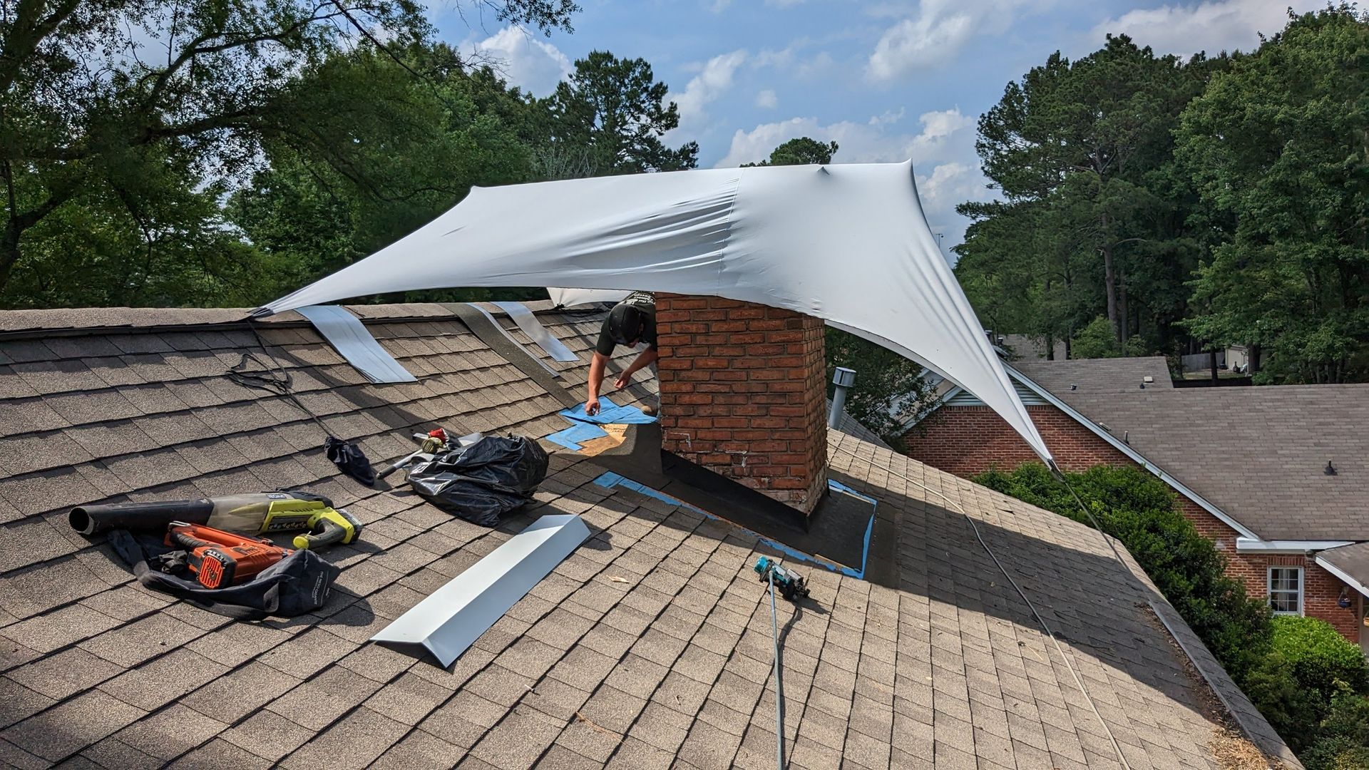 A man is working on the roof of a house.