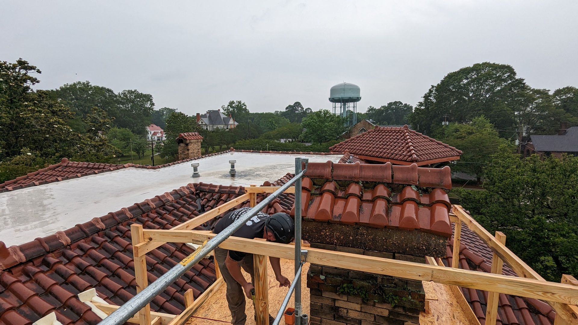 A man is working on the roof of a building.