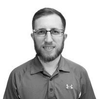 A man with a beard and glasses is wearing a under armour shirt.