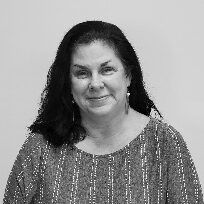 A black and white photo of a woman wearing a striped shirt and earrings.