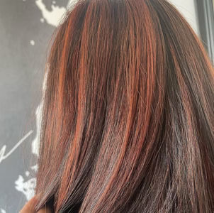 Close-up view of straight brown hair featuring vibrant, reddish-copper highlights throughout for a Birminham,