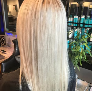 Blonde hair, straight and long, in a salon setting.