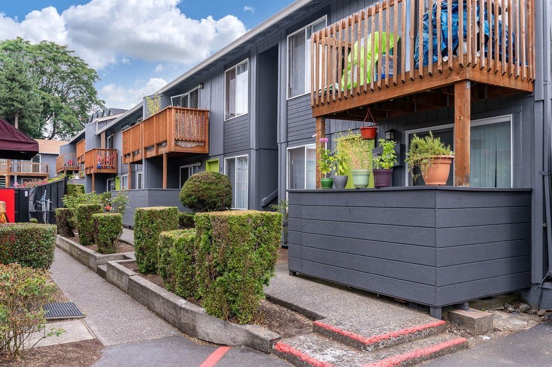 Photo of an apartment community, with two story buildings that have patios and balconies