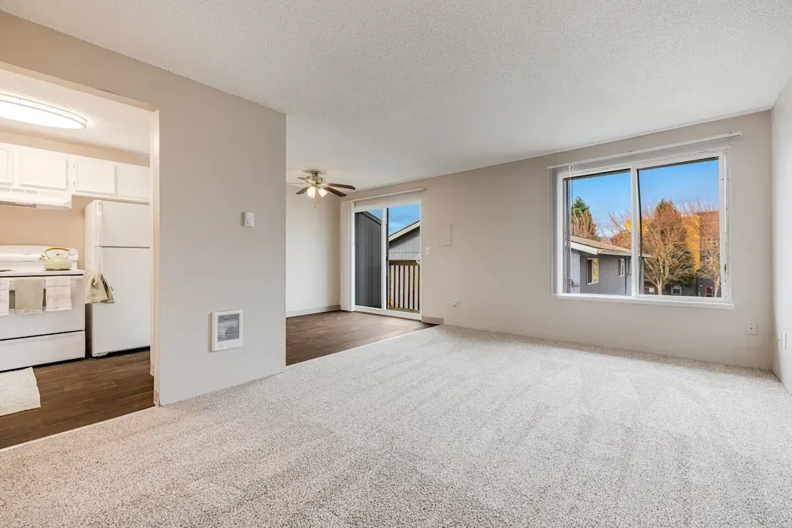 Photo of a living room with the kitchen and dining area off to the side of the photo