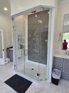 A bathroom with a walk in shower and a sink.