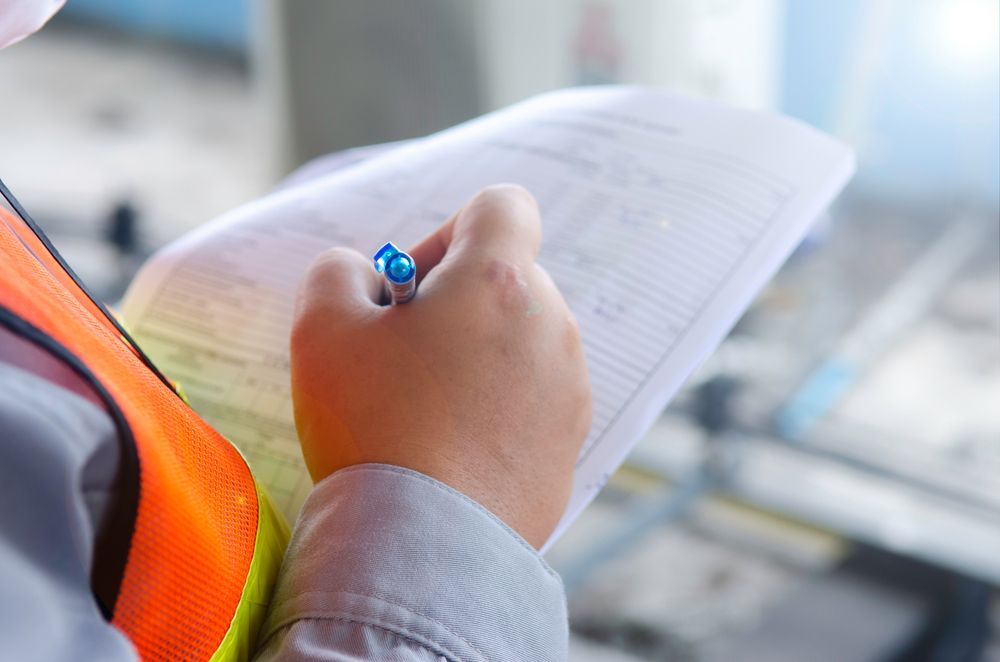 A Person is Writing on a Piece of Paper With a Pen — All About Conveyancing Taree In Taree, NSW