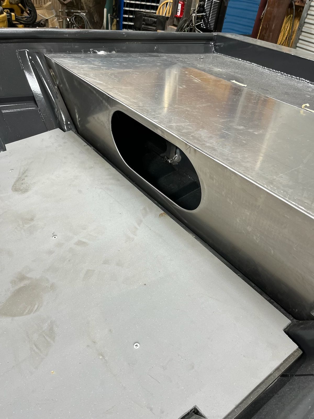 A close-up of a metal box with an oval-shaped hole in an industrial setting.