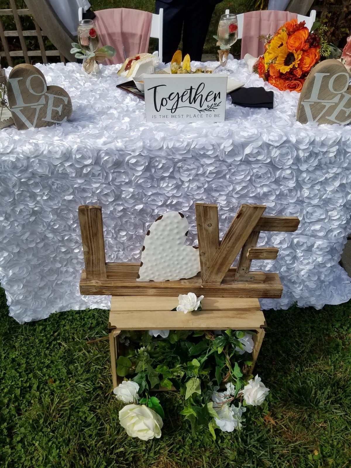 A wedding sweetheart table with a white rose tablecloth, an