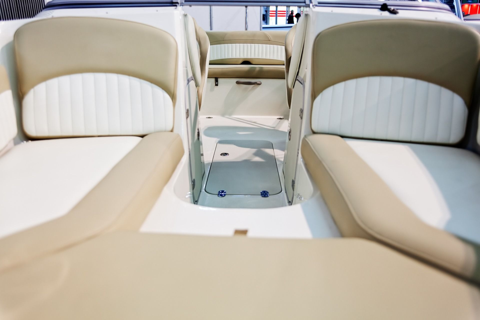 Cream-colored boat seating with a central aisle and cup holders on deck