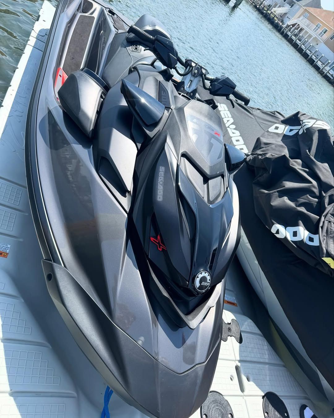Black and gray Sea-Doo jet ski on a dock, ready for use.