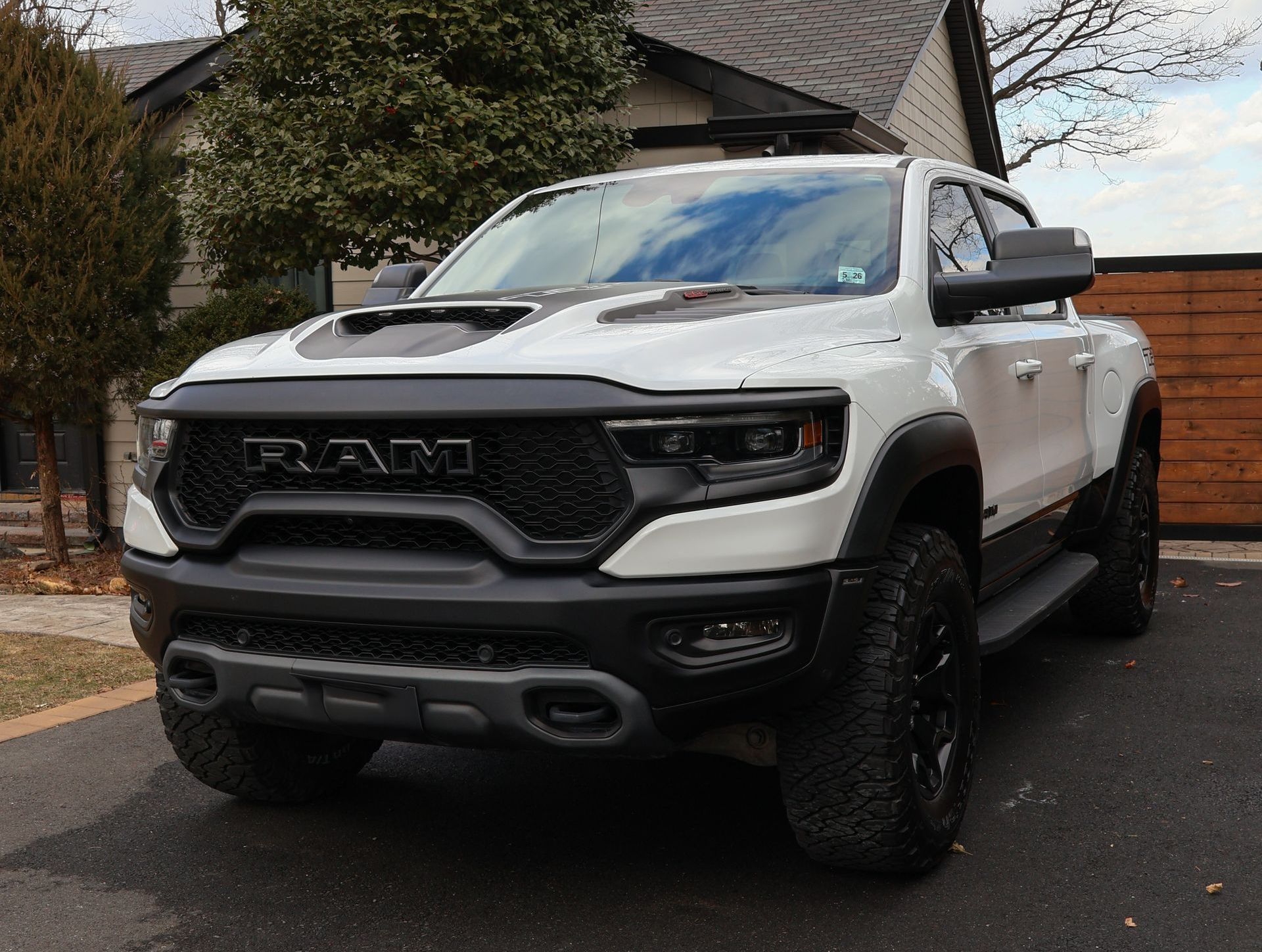 White RAM TRX pickup truck parked on a paved driveway; black accents, front-facing.
