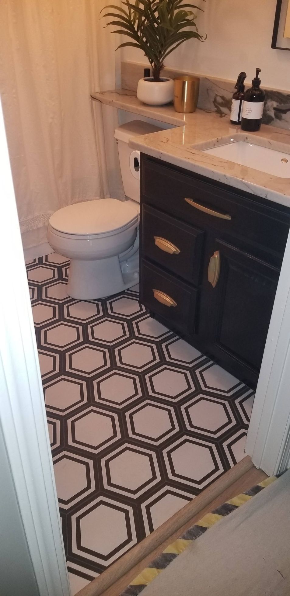 Empty room with gray tile floor and white built-in cabinets around a brick fireplace.