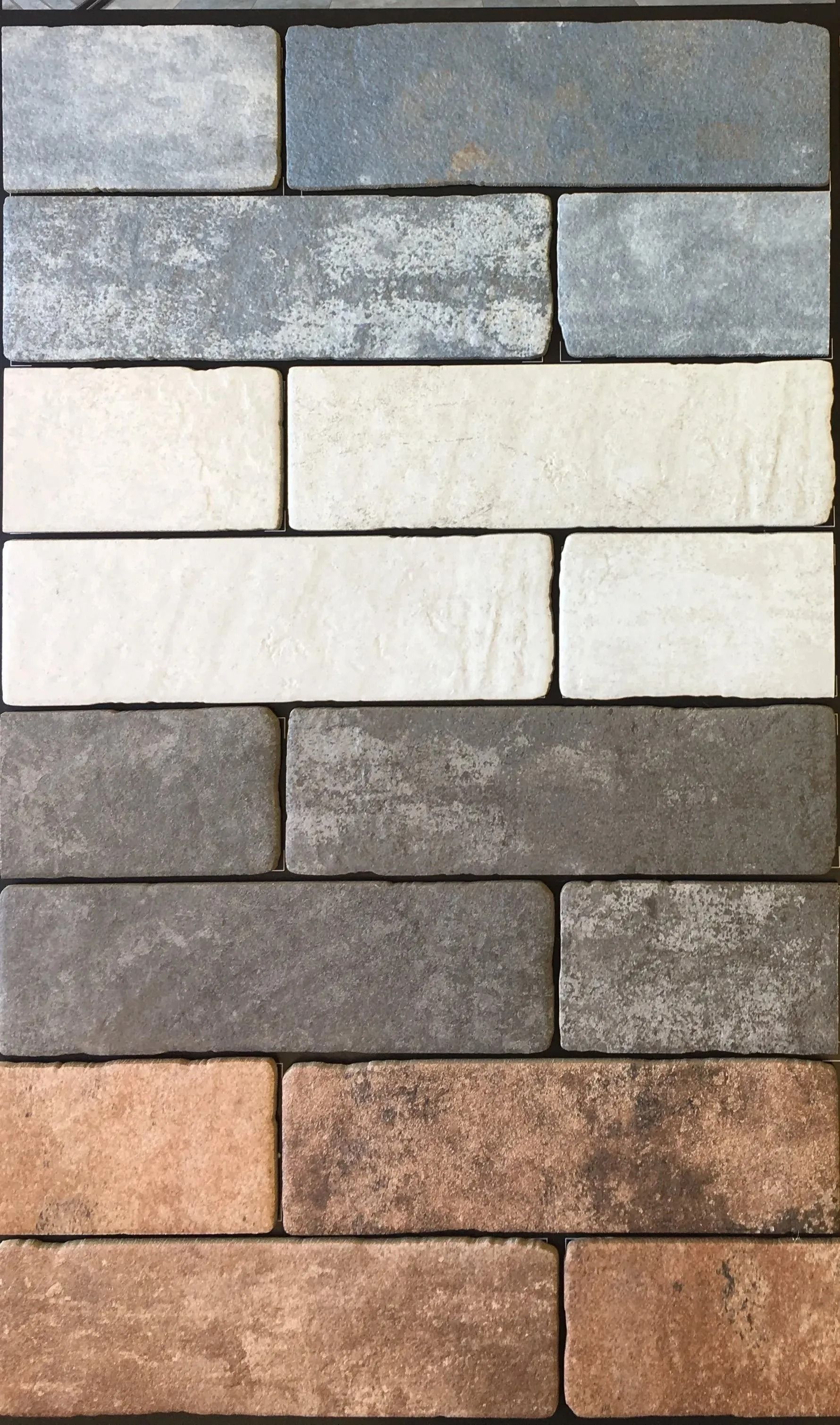 Stacked rectangular stone pavers in blue-gray, white, gray, and tan tones.